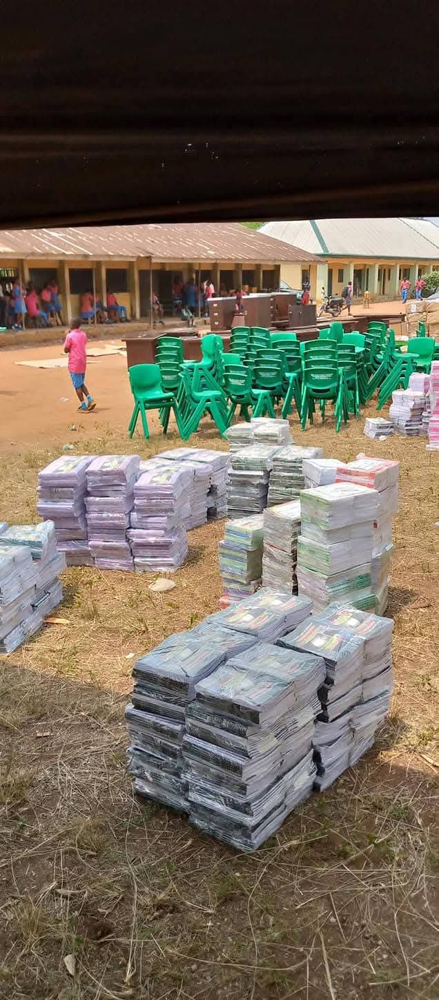 Exercise books, textbooks and school chairs laid out for distribution at a school